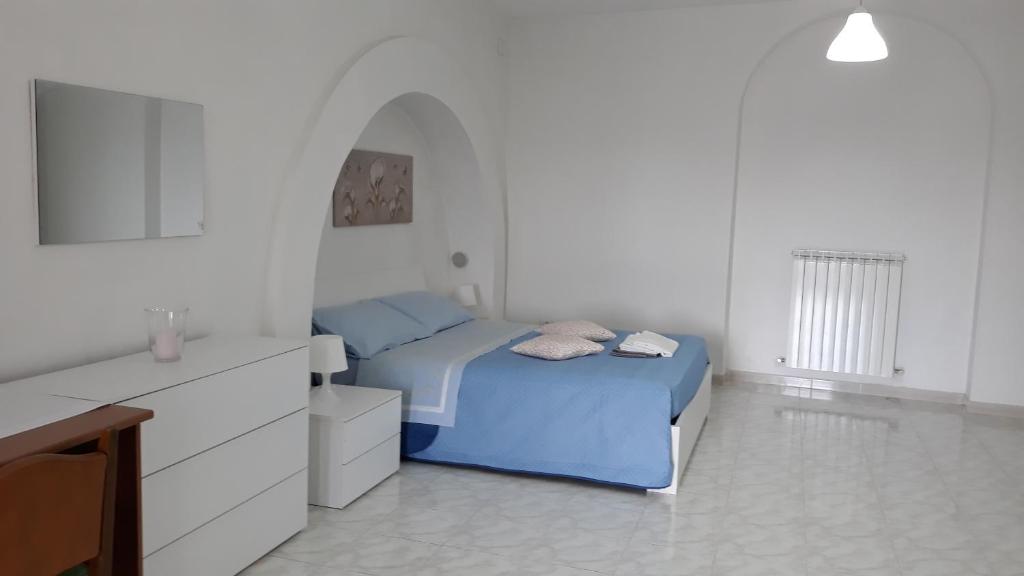 Dormitorio blanco con cama azul y lavamanos en Appartamento con incantevole panorama: Chieti alta, en Chieti