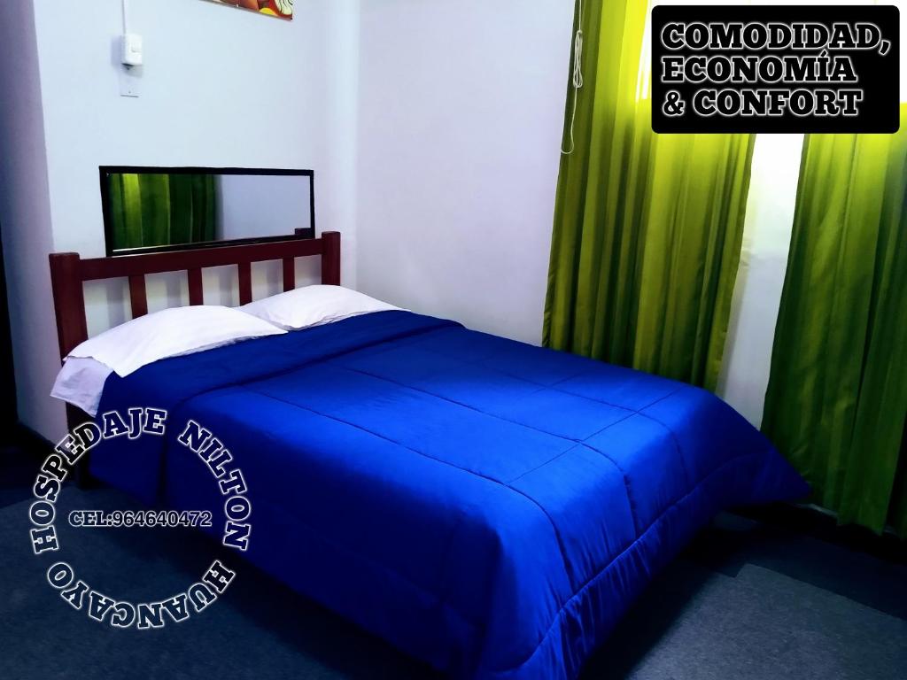 1 dormitorio con cama azul y cortinas verdes en Hospedaje Nilton Huancayo, en Huancayo