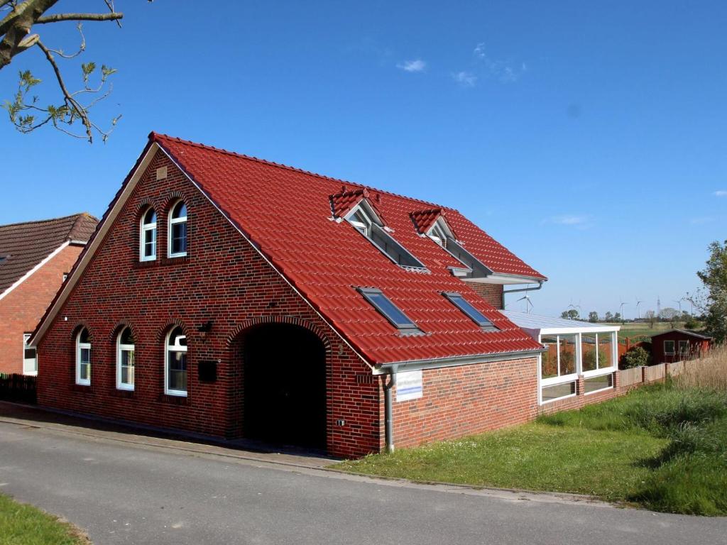 a red brick building with a red roof at House Seewind, Dornumersiel in Dornumersiel