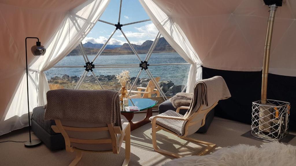 a room with chairs and a table and a large window at Jotunheimen Arctic Domes in Beitostøl
