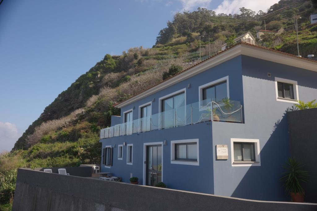 uma casa azul com uma colina ao fundo em Casa Azul - Ocean View em Porto Moniz