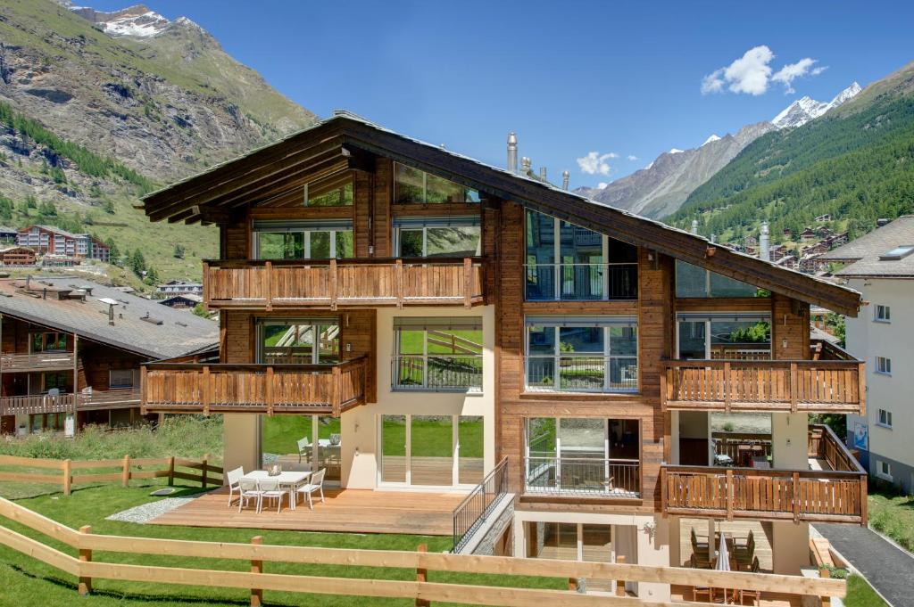 a house in the mountains with a deck at Casa delle Stelle in Zermatt