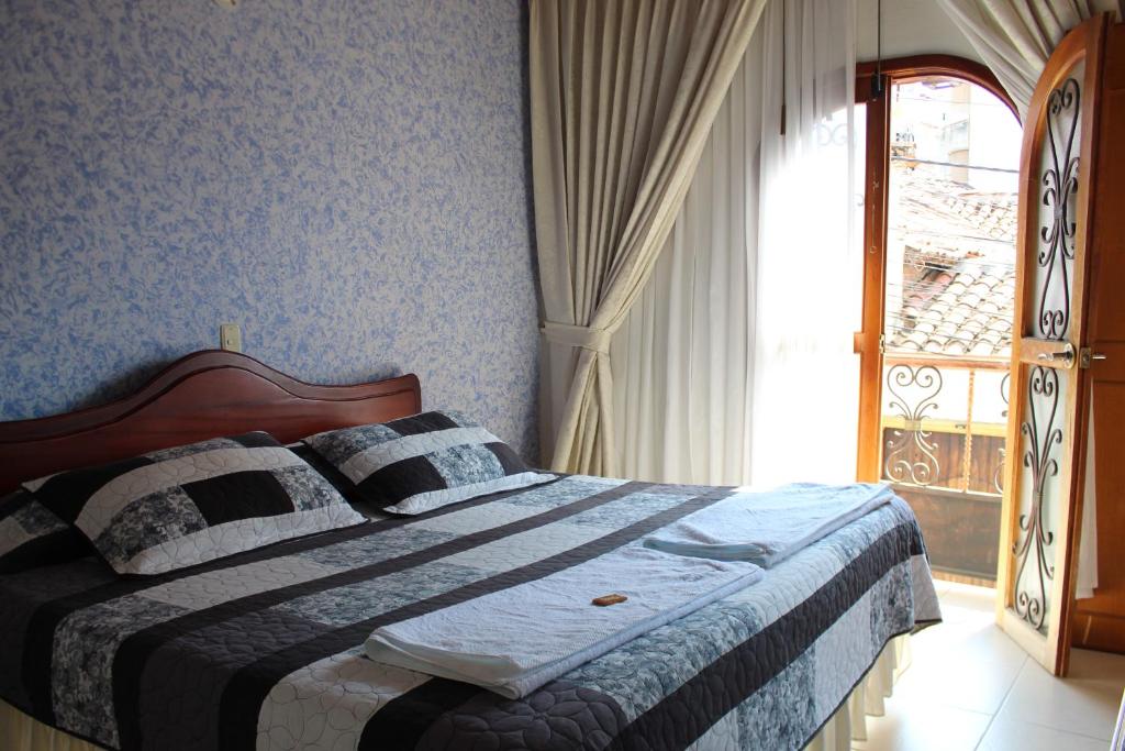 a bedroom with a bed and a window with a view at Hostal Isla Señorial in San Gil