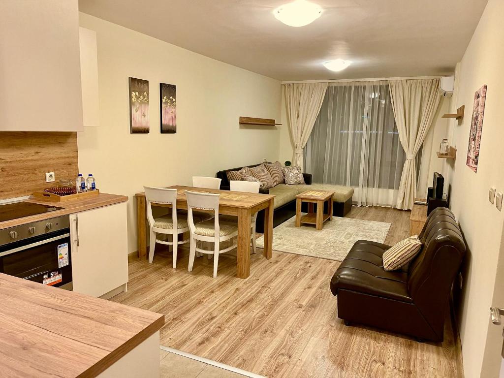 una cucina e un soggiorno con tavolo e divano di Pirin Dream View Apartments a Razlog