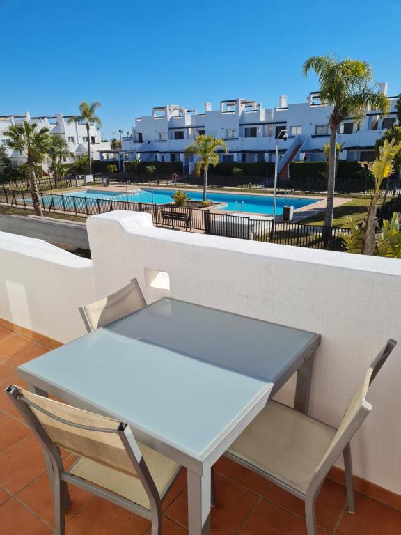a table and chairs on a balcony with a pool at Condado de Alhama N478 in Alhama de Murcia