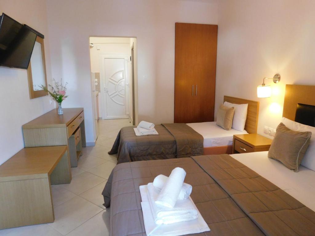 a hotel room with two beds and a television at Anna House 2 in Sarti