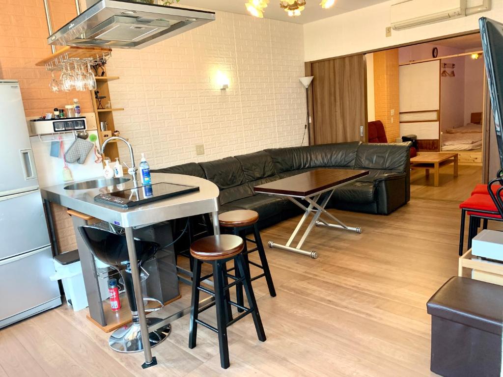 YokohamaKannai HouseBar في يوكوهاما: مطبخ وغرفة معيشة مع أريكة وطاولة
