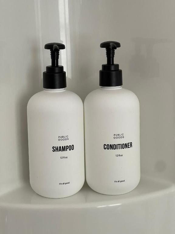 two bottles of shampoo and conditioner sitting on a shelf at The Archie & Isidore Hotel in Chéticamp