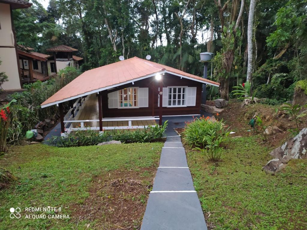 una pequeña casa con un camino delante de ella en UBATUBA, SP - BRASIL - PRAIA DO FELIX - Casa do Aconchego en Ubatuba