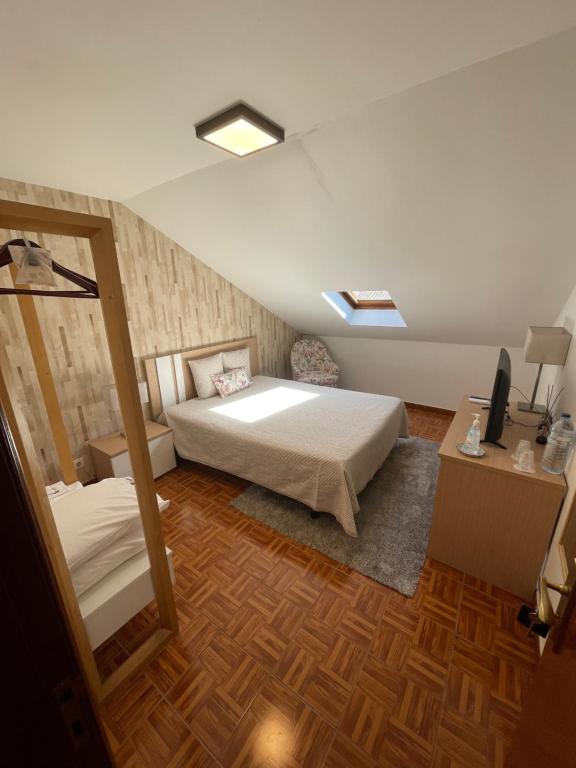 um quarto com uma cama e uma televisão em Guest House TOWERCC em Figueiró dos Vinhos