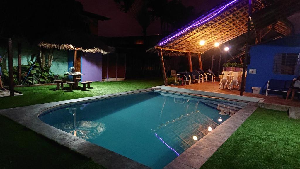 a swimming pool in front of a house at night at La casa de naty by Ecuapolsky in Tonsupa