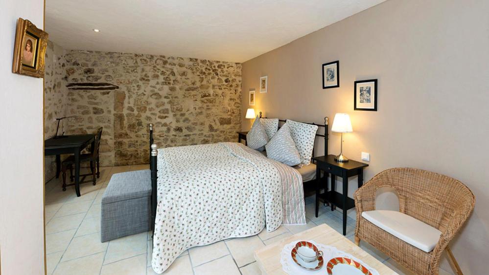een slaapkamer met een bed en een bureau in een kamer bij Maison des Anges in Bouin