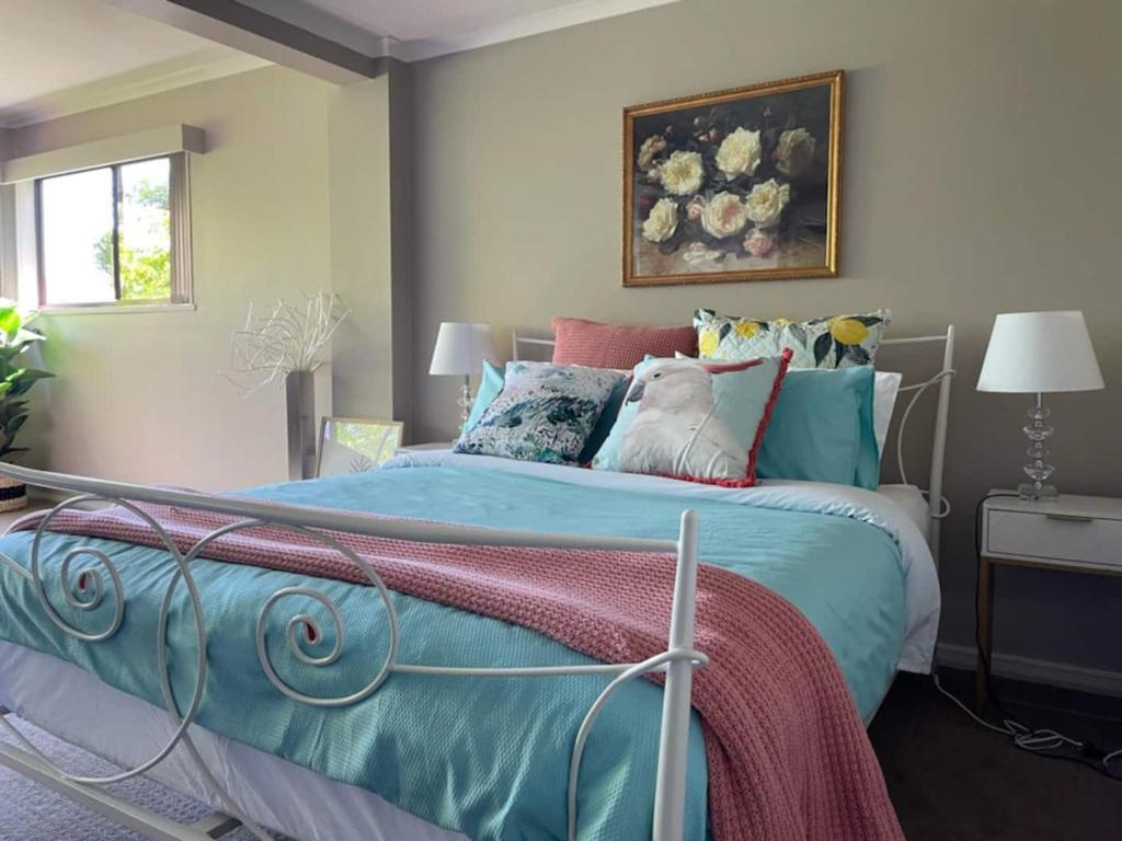 a bedroom with a bed with colorful pillows at Hobart panoramic view with Spas in Hobart