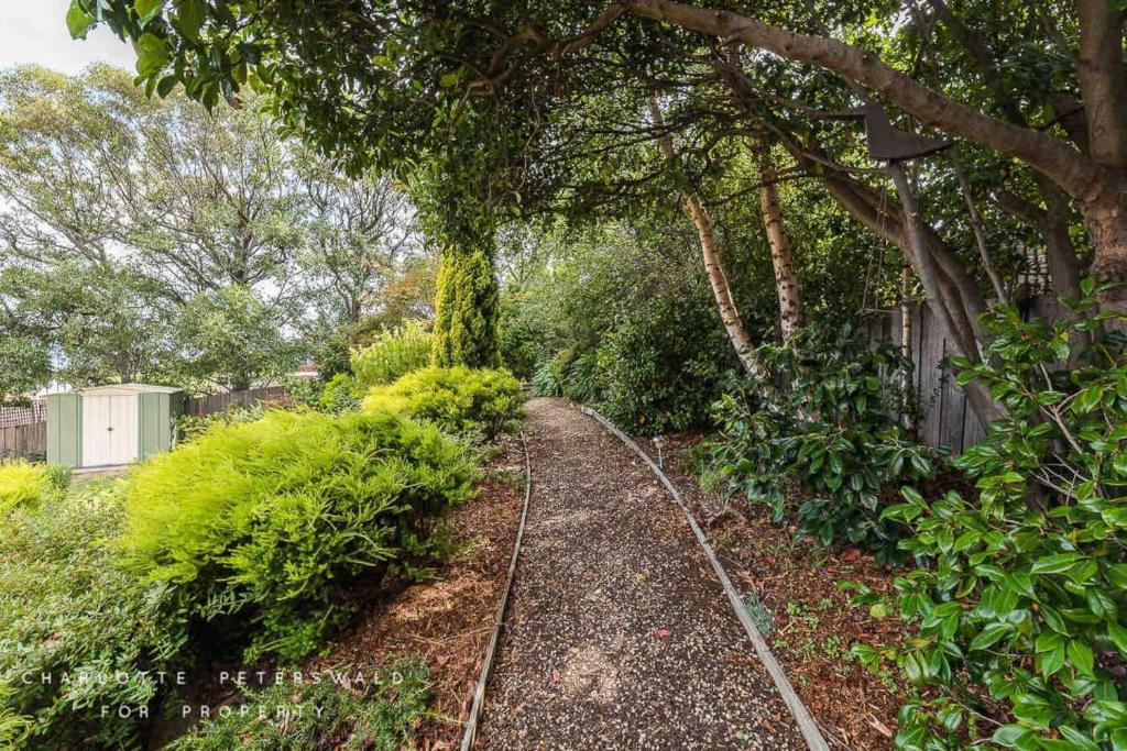 a garden path with trees and a fence at Hobart panoramic view with Spas in Hobart