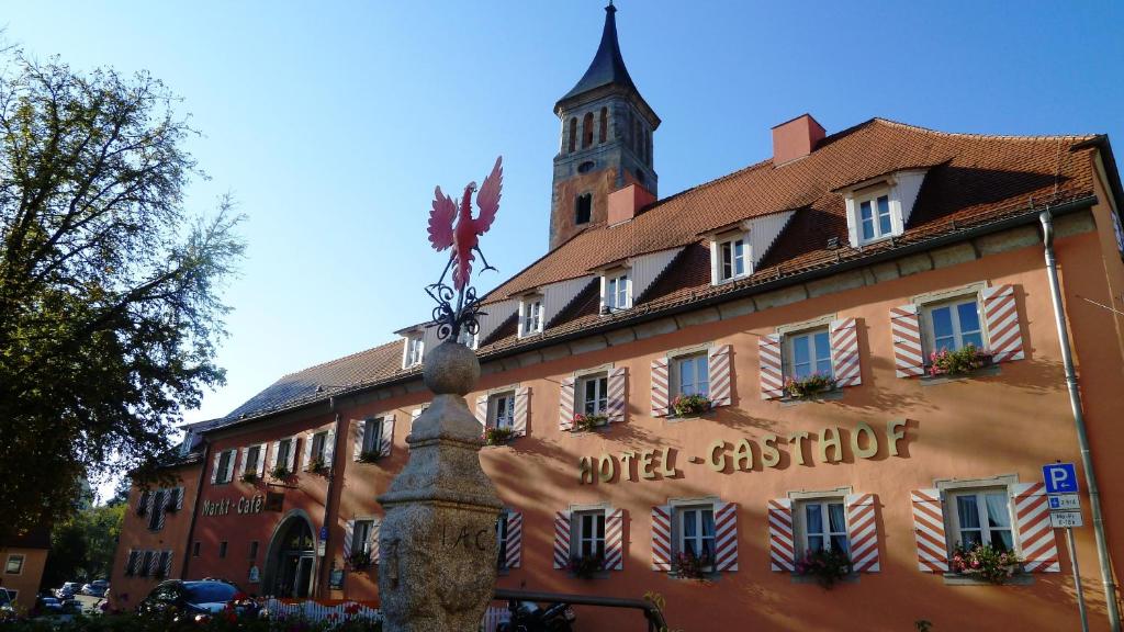 un edificio con una torre de reloj encima en Meister BÄR HOTEL Ostbayern en Floß