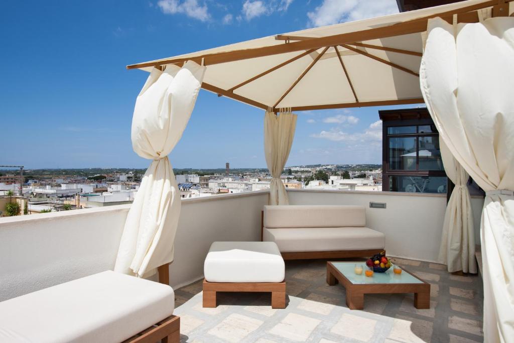 - un balcon avec 2 chaises et un parasol dans l'établissement Active Life Exclusive B&B, à Parabita