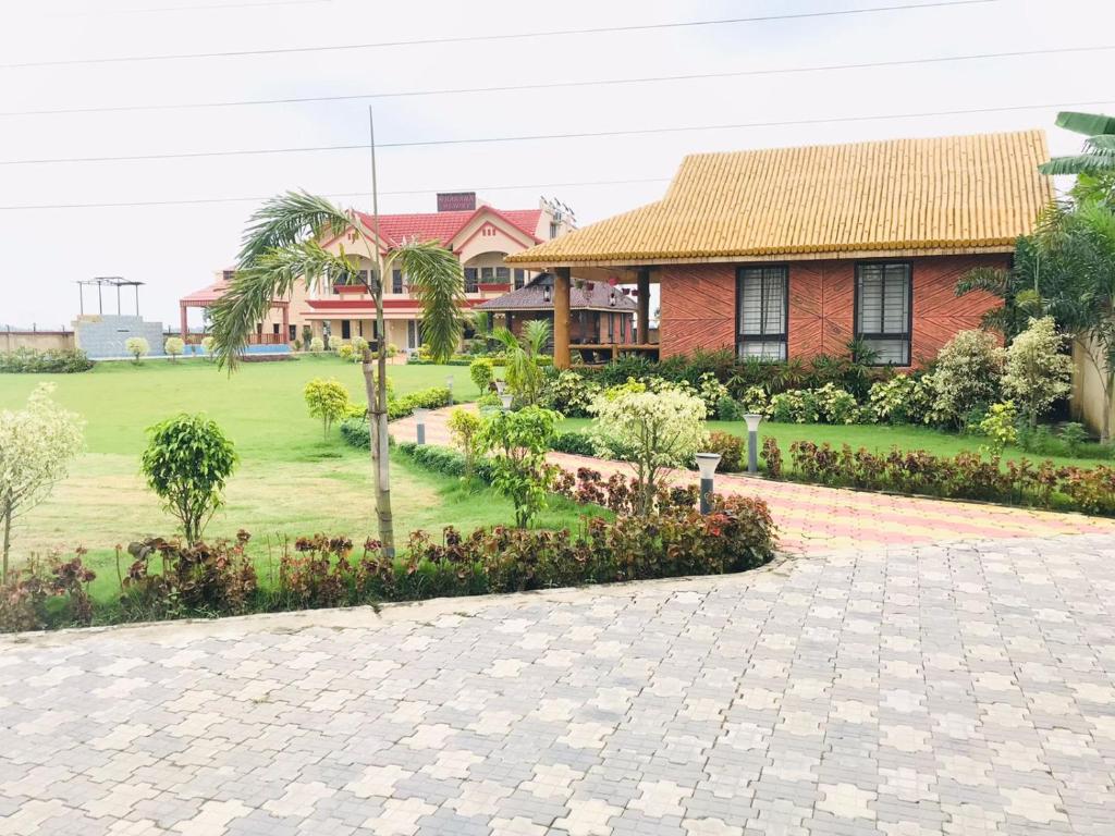 a house with a garden in front of a house at Gharana Resort in Singur