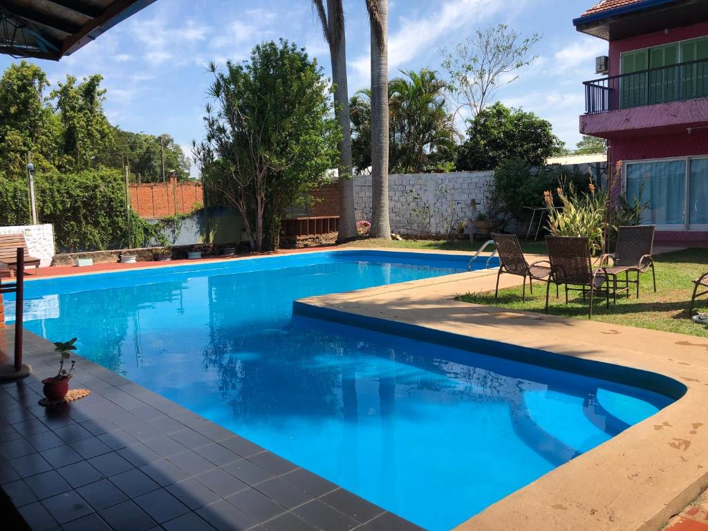 una piscina de agua azul en un patio en Guembe al Rio Hostel en Puerto Iguazú