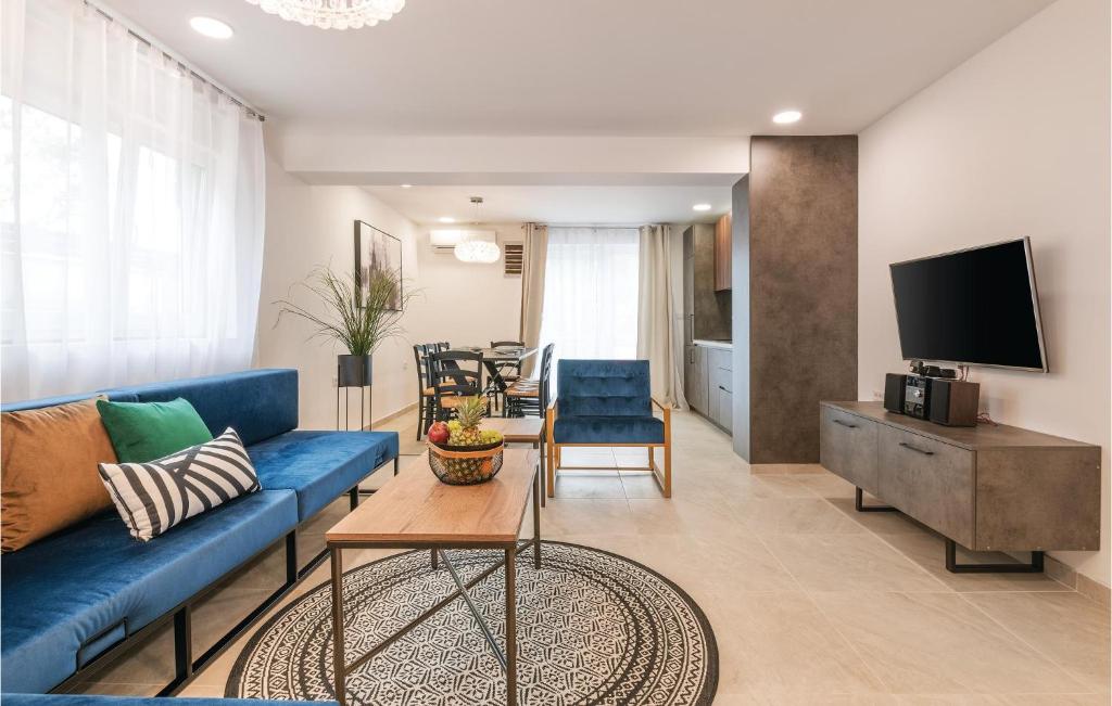 ein Wohnzimmer mit einem blauen Sofa und einem TV in der Unterkunft Awesome Apartment In Fazana With 2 Bedrooms And Wifi in Fažana