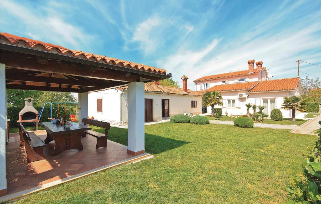 un patio trasero con una terraza de madera y una casa en Holiday Home Hrboki Iii, en Hrboki