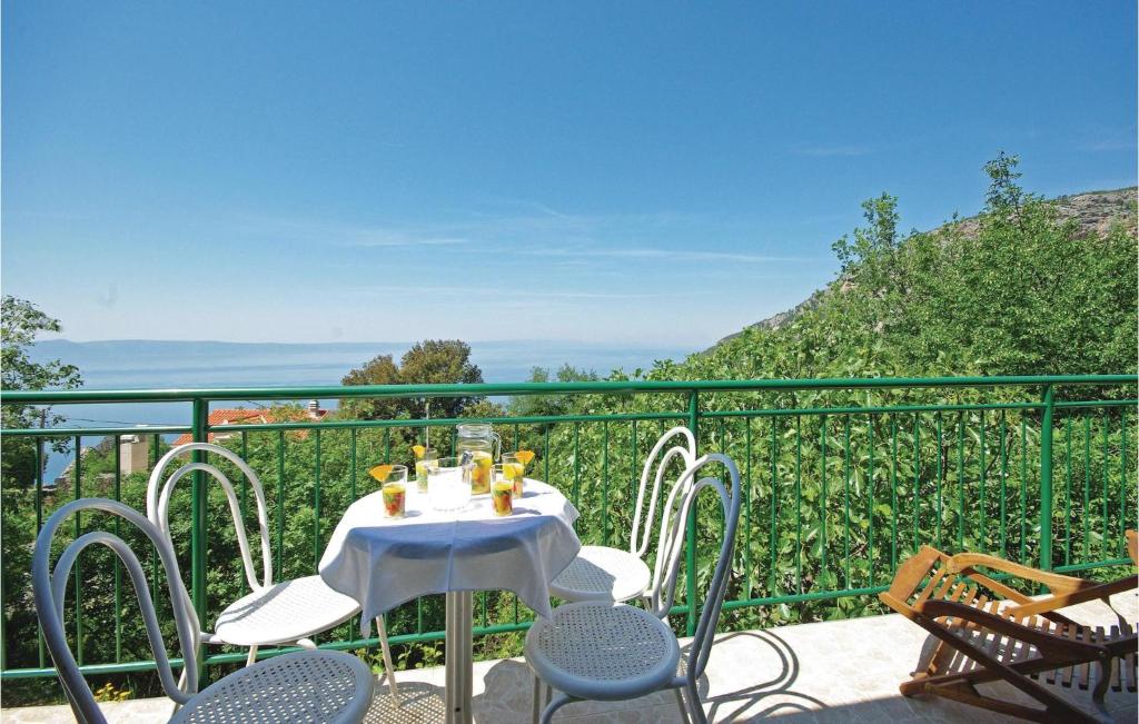 een tafel en stoelen op een balkon met uitzicht bij Beautiful Home In Gornje Tucepi With House Sea View in Tučepi