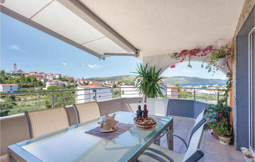 a table and chairs on a balcony with a view at Cozy Apartment In Seget Vranjica With Wifi in Seget Vranjica