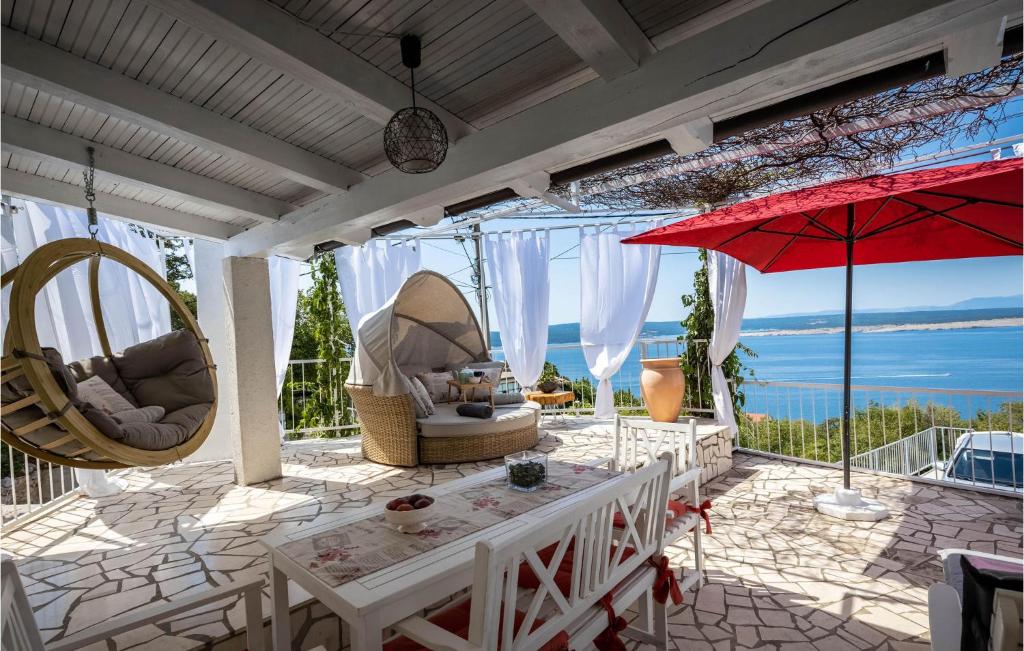a patio with chairs and umbrellas and the ocean at Cozy Home In Crikvenica With Kitchen in Crikvenica