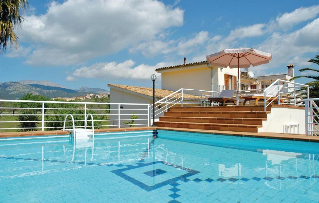 a swimming pool with two chairs and an umbrella at Amazing Home In Campanet With Outdoor Swimming Pool in Campanet