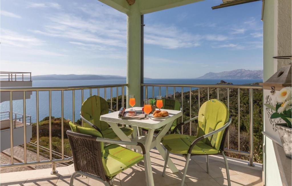 a table and chairs on a balcony with a view of the ocean at Beautiful Apartment In Krvavica With Wifi in Krvavica