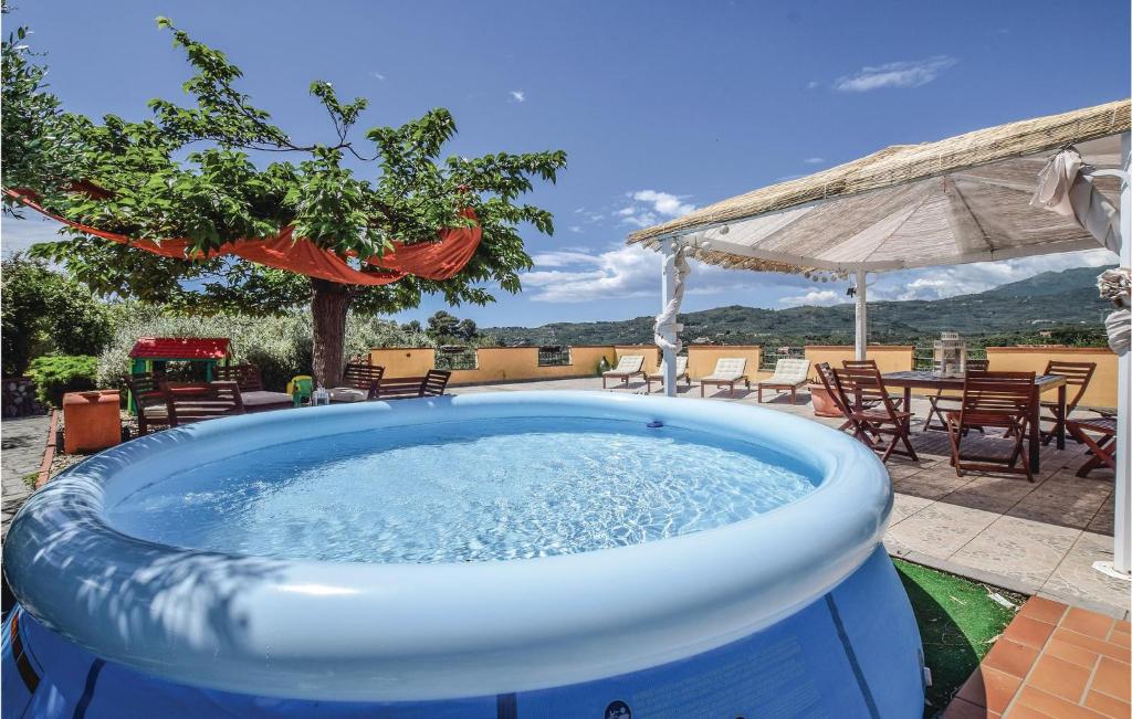 uma grande banheira de hidromassagem azul num pátio com mesas e cadeiras em Villa Camilla em Artallo