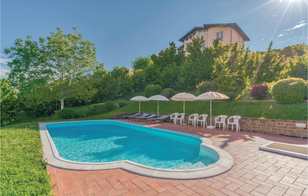 - une piscine dans une cour avec des chaises et des parasols dans l'établissement Villa Bellavista, à Lequio Tanaro