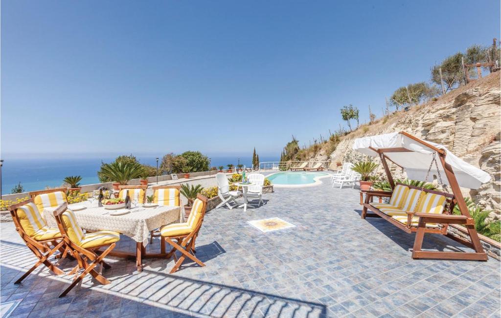 オリアストロ・チレントにあるBeautiful Home In Agropoli Sa With House Sea Viewのプールサイドのパティオ(テーブル、椅子付)