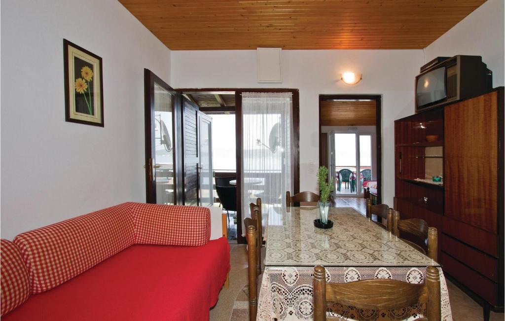 a living room with a red couch and a table at Awesome Apartment In Sv, Petar With 2 Bedrooms And Wifi in Sveti Petar