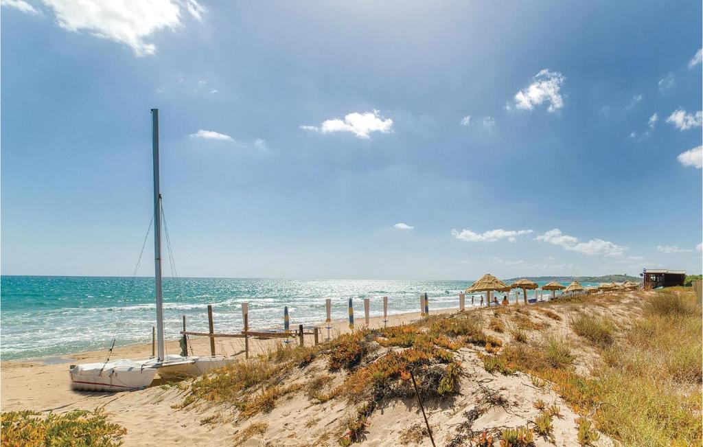 piaszczystą plażę z parasolami i oceanem w obiekcie Villa Caterina w mieście Menfi