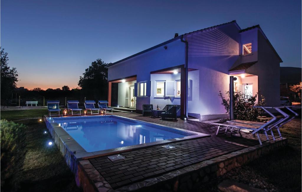 a swimming pool in front of a house at night at Stunning Home In Kastel Novi With 3 Bedrooms, Private Swimming Pool And Outdoor Swimming Pool in Kaštela