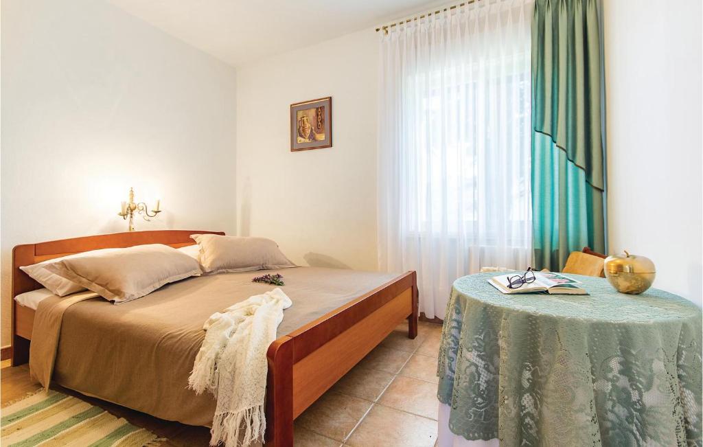 sypialnia z łóżkiem i stołem w obiekcie Holiday Home Vrcevan I w Medulinie