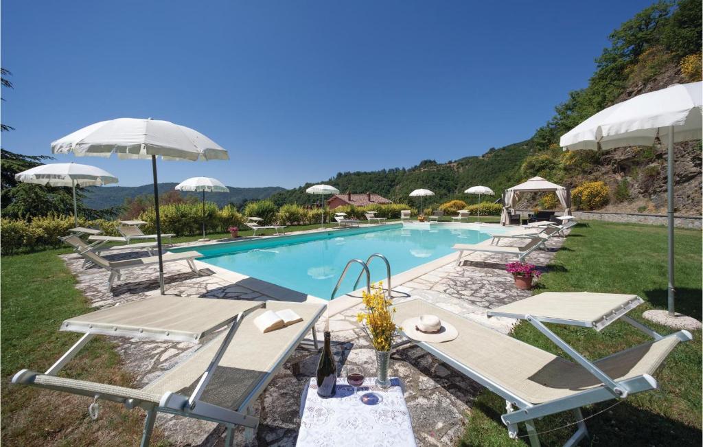 een zwembad met stoelen en parasols bij Villa Margherita in Poggioni