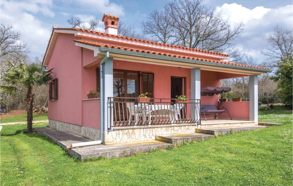 een klein roze huis met een balkon bij Awesome Home In Bateli With Wifi in Želiski
