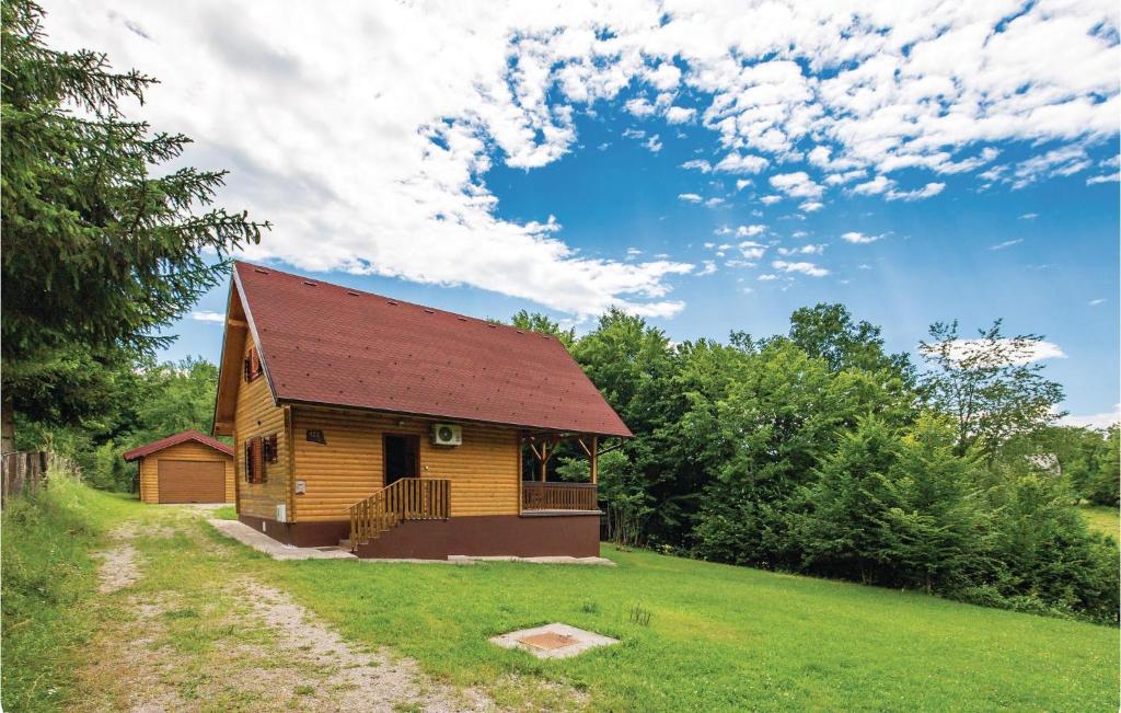 Lički Osik的住宿－Beautiful Home In Licki Osik With Kitchen，绿色田野上带红色屋顶的小房子