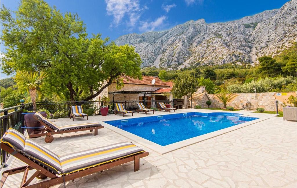 uma piscina com espreguiçadeiras e uma montanha em Pet Friendly Home In Orebic With Jacuzzi em Orebić