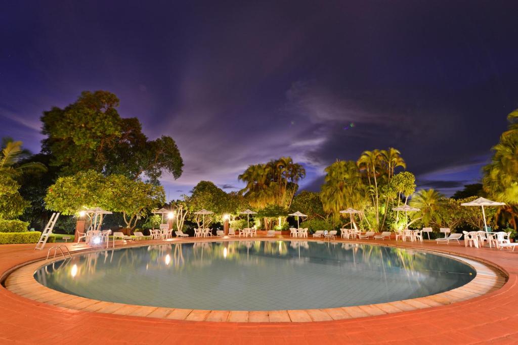 a swimming pool in a park at night at Hotel Deville Express Guaira in Guaíra