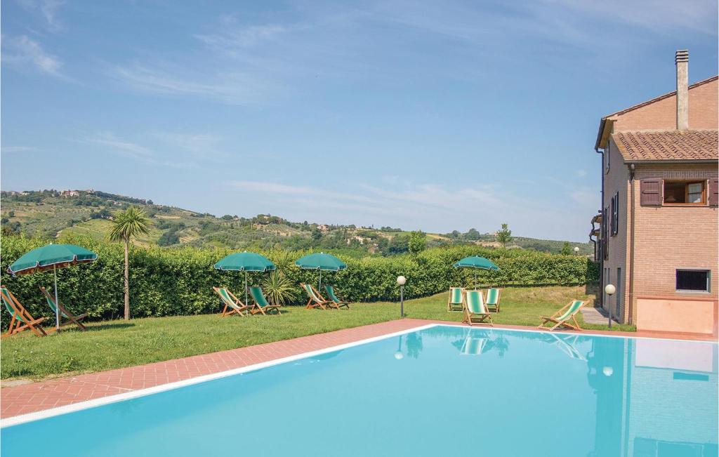uma piscina com espreguiçadeiras e guarda-sóis em Beautiful Apartment In Montaione fi With Outdoor Swimming Pool em Querce