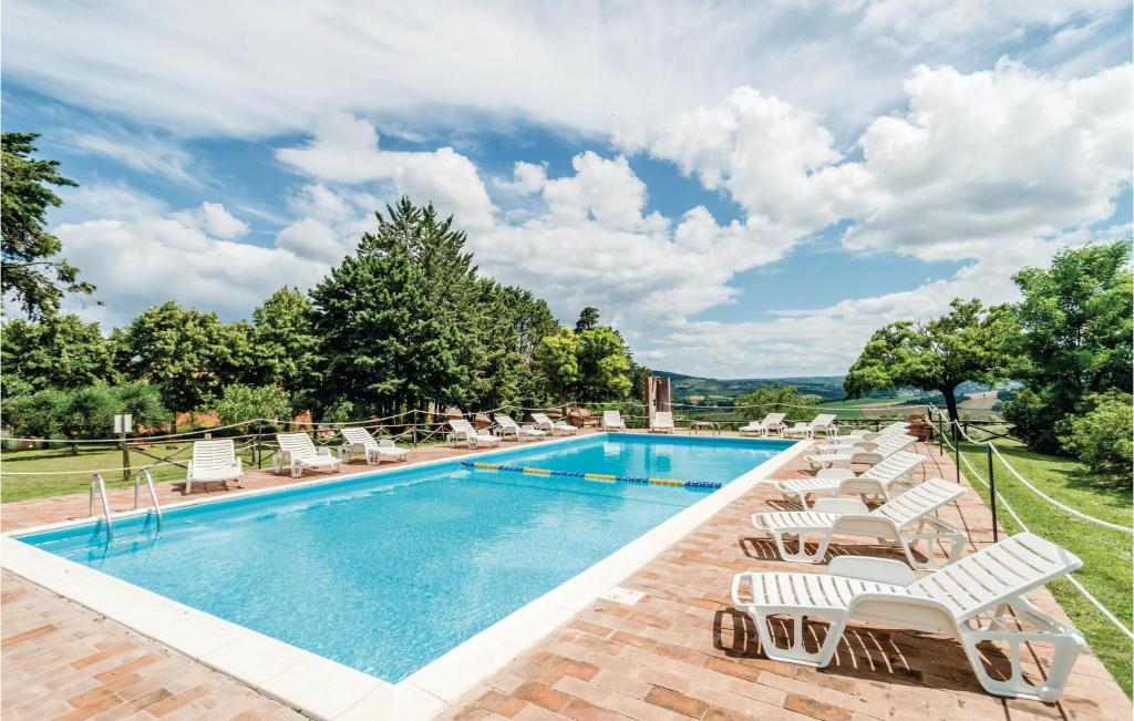 StradaにあるBeautiful Apartment In Castiglione D,lago Pg With 1 Bedrooms, Wifi And Outdoor Swimming Poolのラウンジチェア付きのプール、スイミングプールを提供しています。