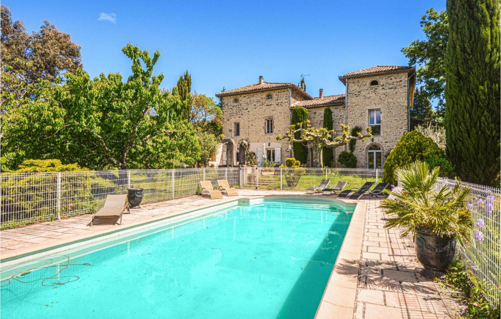 a swimming pool in front of a house at Cozy Home In Saint-ambroix With Heated Swimming Pool in Saint-Ambroix