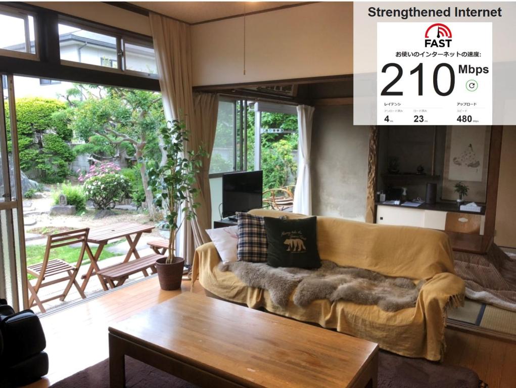 uma sala de estar com um sofá e uma mesa em Gunma House em Maebashi