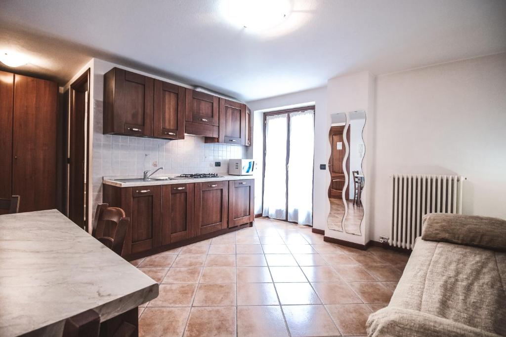 kuchnia z drewnianymi szafkami i podłogą wyłożoną kafelkami w obiekcie Residence Aquila - Mono Chamousira w mieście Brusson