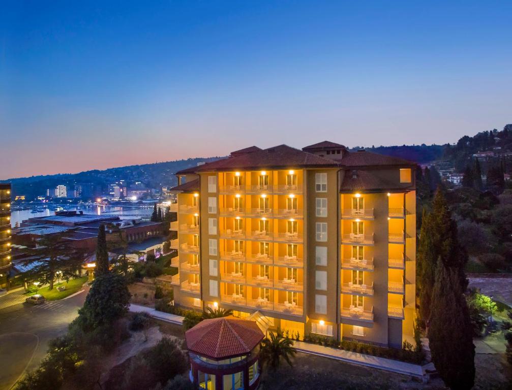 a building with lights on in a city at night at Remisens CASA ROSA - Hotel Metropol Annexe in Portorož