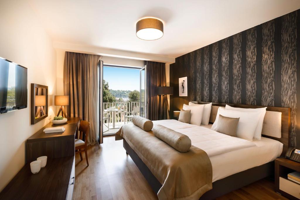 a hotel room with a large bed and a balcony at Remisens BEL MORETTO - Hotel Metropol Annexe in Portorož