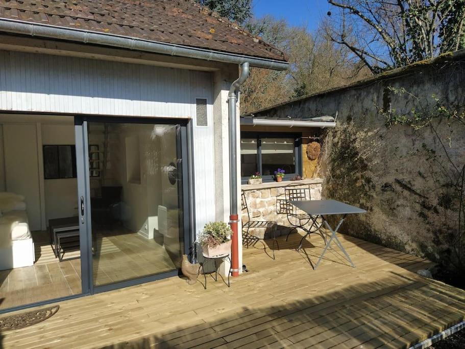 une terrasse en bois avec une table. dans l'établissement La Hotte des écureuils, à Château-Thierry