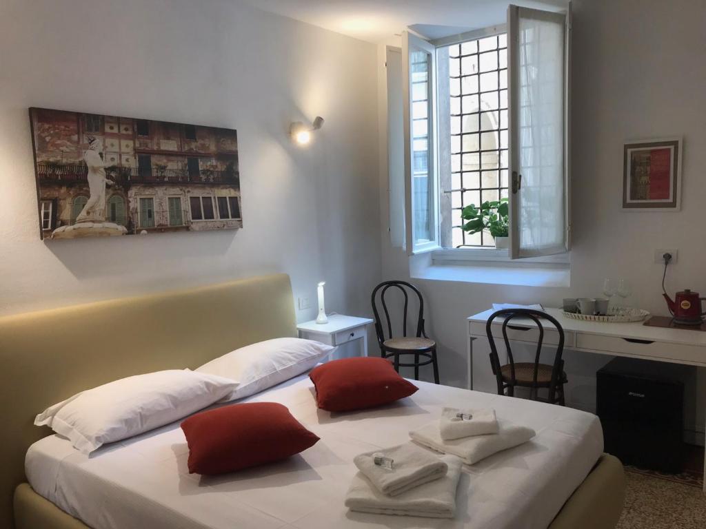 een slaapkamer met 2 bedden, een bureau en een raam bij Palazzo Della Torre Room in Verona